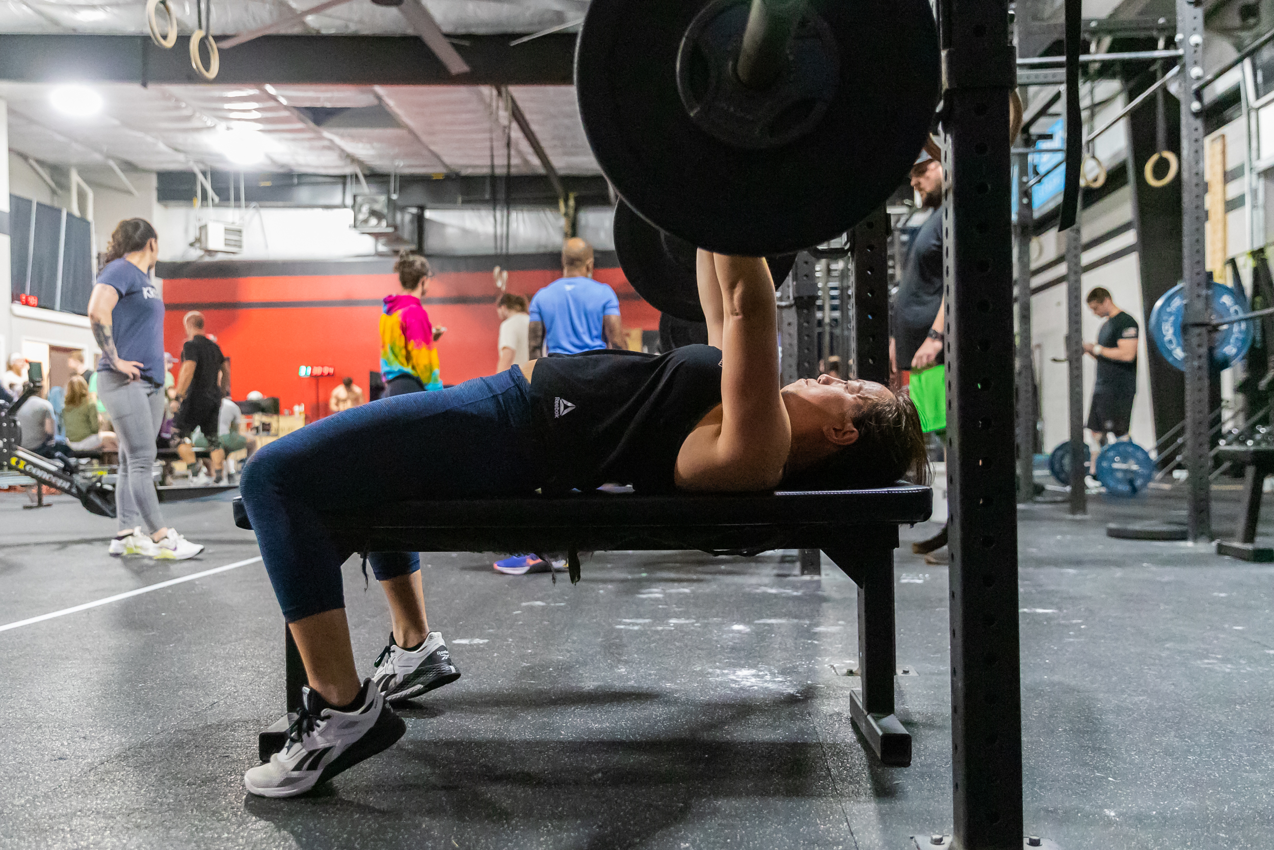 A woman performs a bench press. 