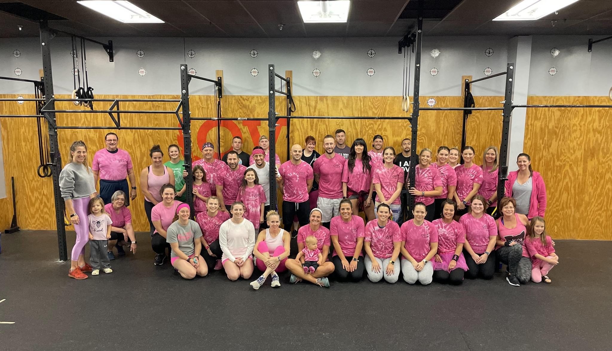 Members of OV CrossFit pose for a photo beneath a pull-up rig